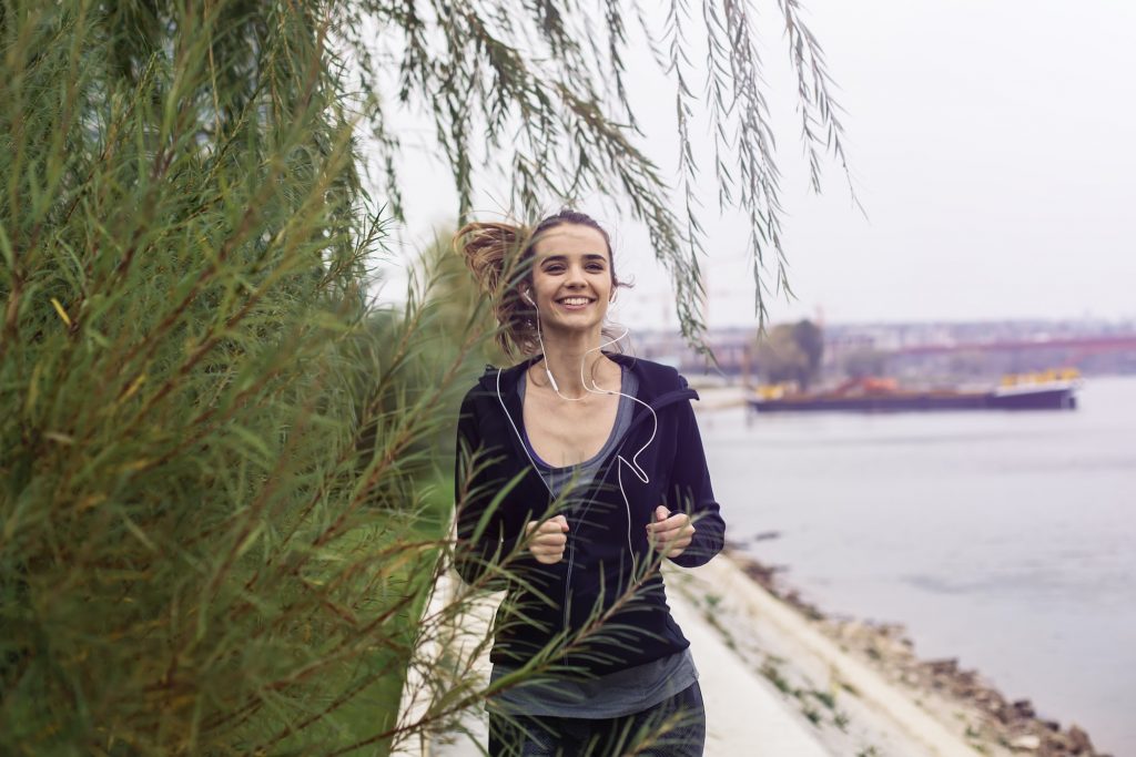 Young woman running outdoor by river